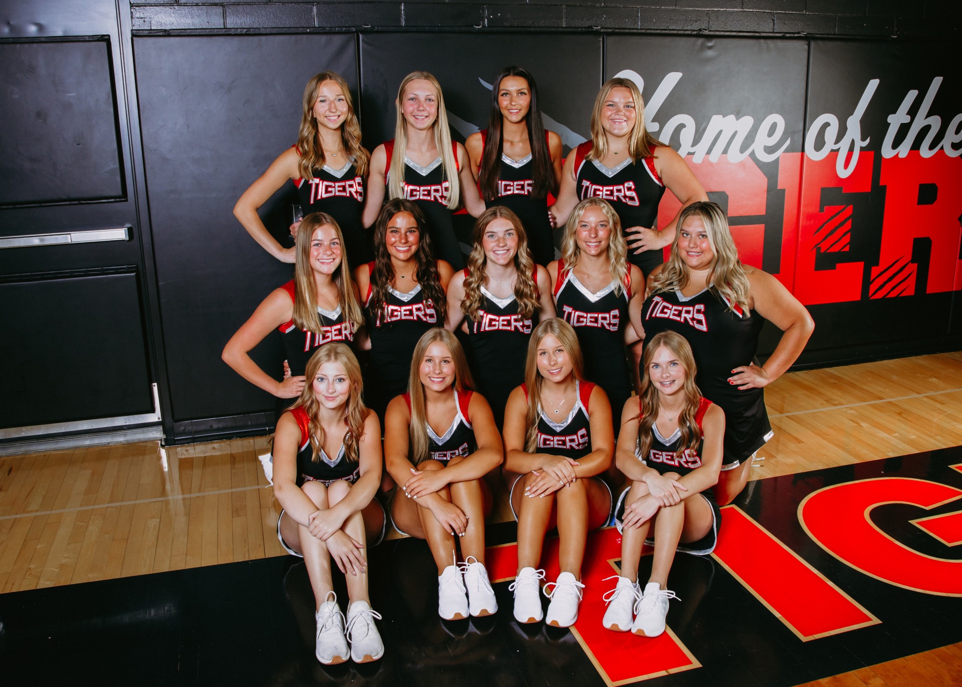 South Hardin Basketball Cheerleaders taking a team picture on their basketball court sidelines.